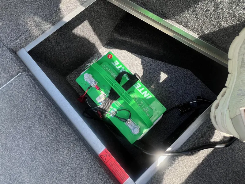 Slide: The Image of Battery compartment in 2007 Lund 1800 Pro-V SE boat, featuring green Interstate battery. - 15