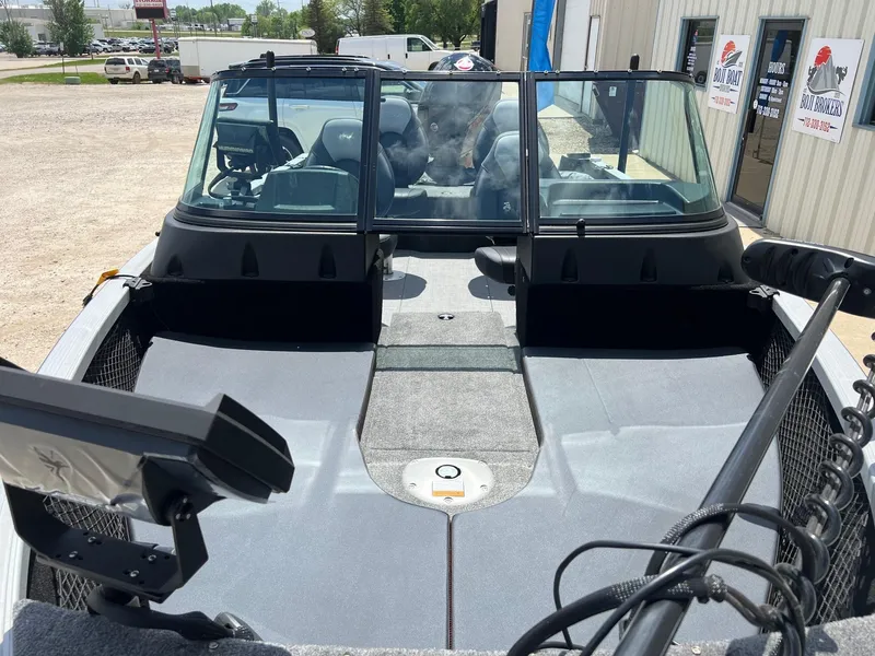 Slide: The Image of 2007 Lund 1800 Pro-V SE boat interior with windshield and seating, parked outdoors. - 5