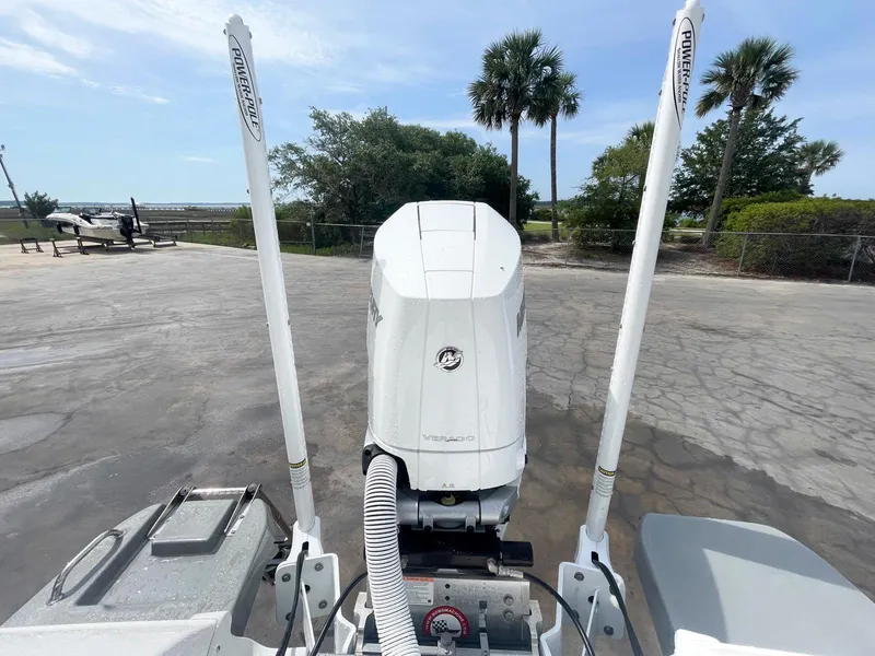 Slide: The Image of 2023 Caymas 26 HB boat engine with Power-Pole anchors, parked near palm trees. - 15