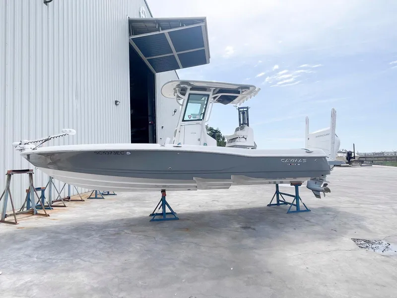 Slide: The Image of 2023 Caymas 26 HB boat on stands outside a large warehouse. - 2