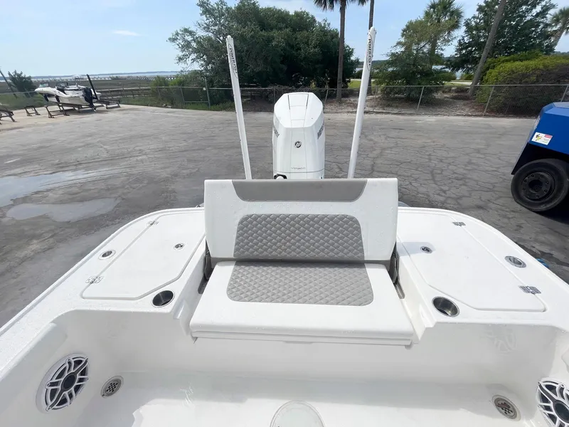 Slide: The Image of 2023 Caymas 26 HB boat with cushioned seating and motor, parked outdoors. - 5