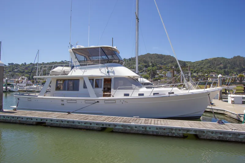 The Image of 1992 Offshore Yachts Sedan moored at a marina under clear blue skies. - 0
