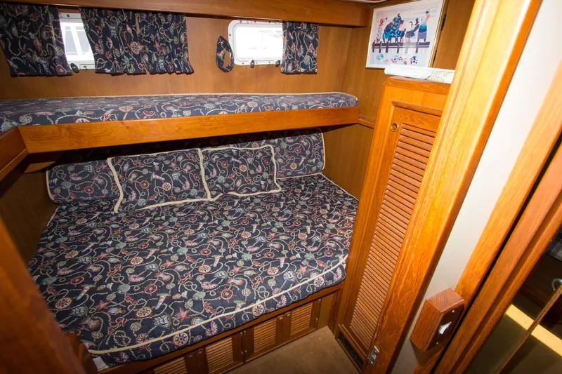 Slide: The Image of 1992 Offshore Yachts Sedan cabin with bunk beds and floral-patterned bedding. - 14