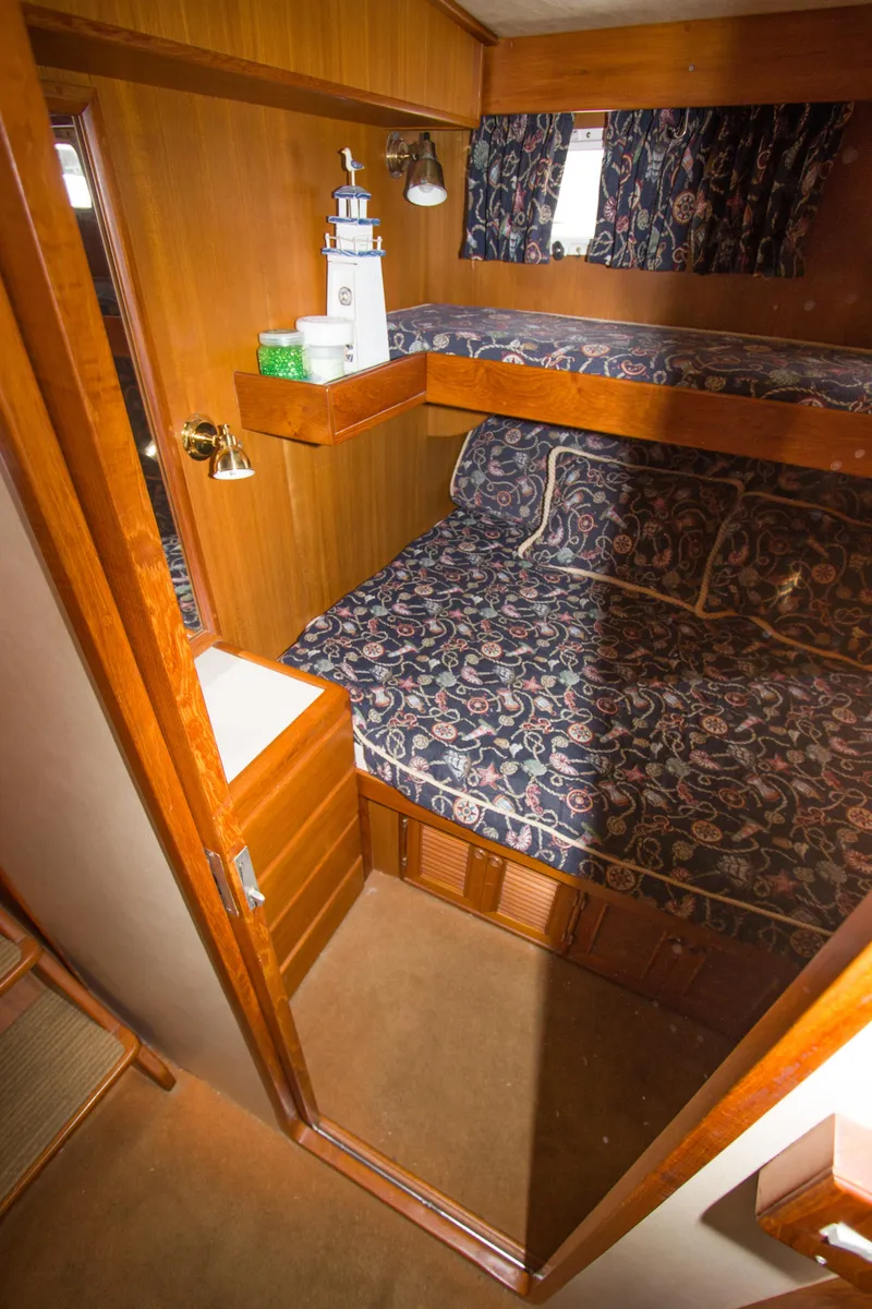 Slide: The Image of 1992 Offshore Yachts Sedan cabin with bunk beds and wooden interior. - 15
