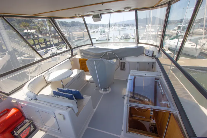 Slide: The Image of 1992 Offshore Yachts Sedan interior with helm, seating, and marina view. - 20