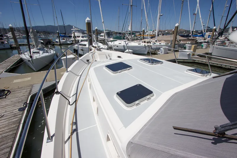 Slide: The Image of 1992 Offshore Yachts Sedan docked at marina, showcasing sleek deck design and hatches. - 26