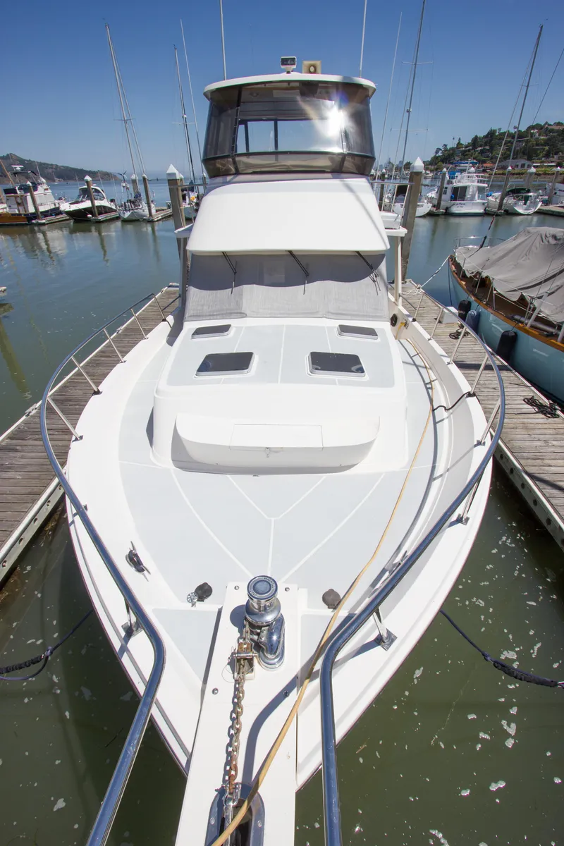 Slide: The Image of 1992 Offshore Yachts Sedan docked at marina, showcasing sleek design and spacious deck. - 27