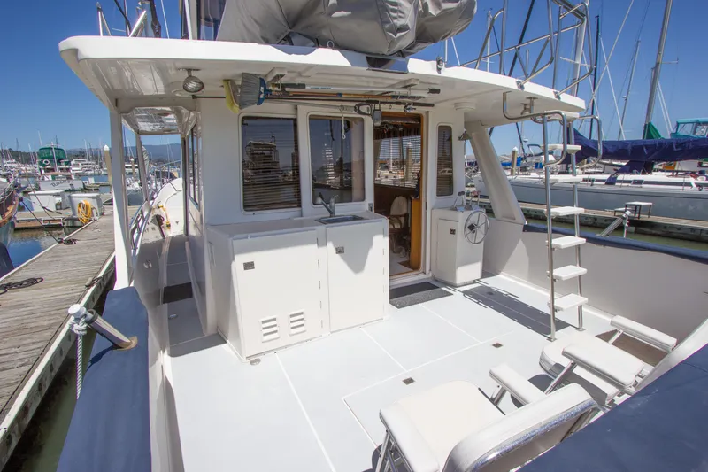 Slide: The Image of 1992 Offshore Yachts Sedan at marina, showcasing spacious deck and seating area under clear blue sky. - 30