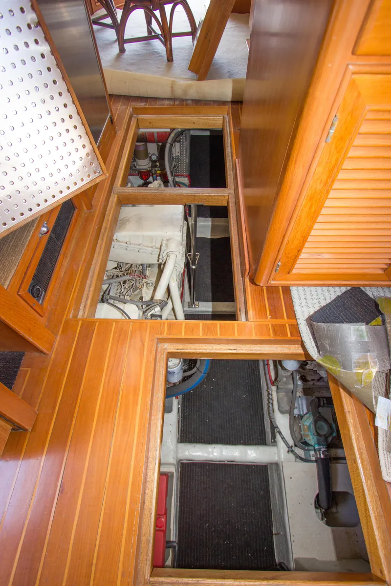 Slide: The Image of 1992 Offshore Yachts Sedan engine room with open floor panels, showcasing mechanical components. - 33