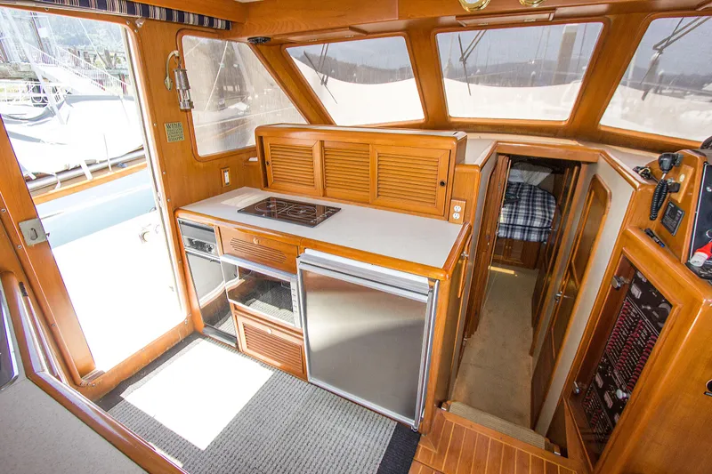 Slide: The Image of 1992 Offshore Yachts Sedan interior with kitchenette, wood finish, and cabin view. - 7