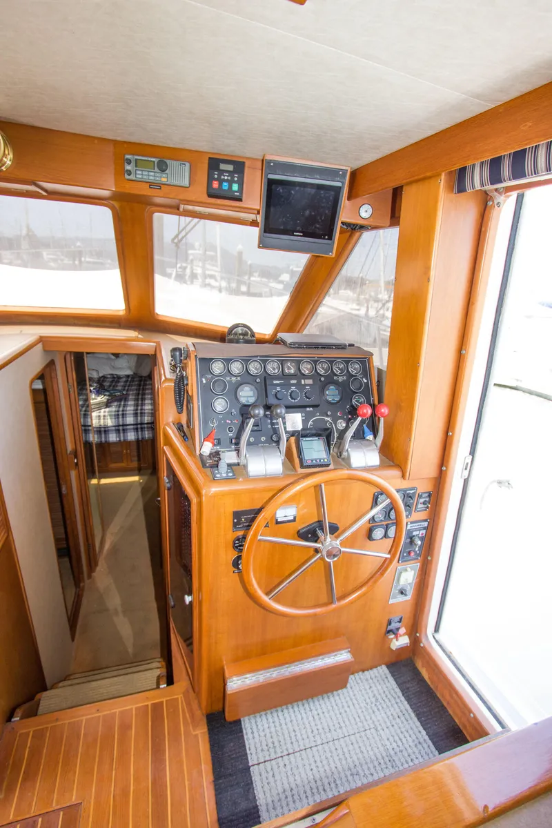 Slide: The Image of 1992 Offshore Yachts Sedan interior with wooden helm and navigation instruments. - 9