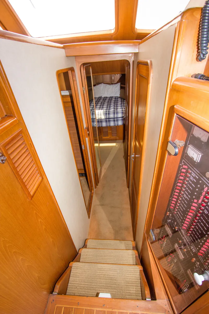 Slide: The Image of Interior view of 1992 Offshore Yachts Sedan, featuring a cozy cabin hallway. - 12