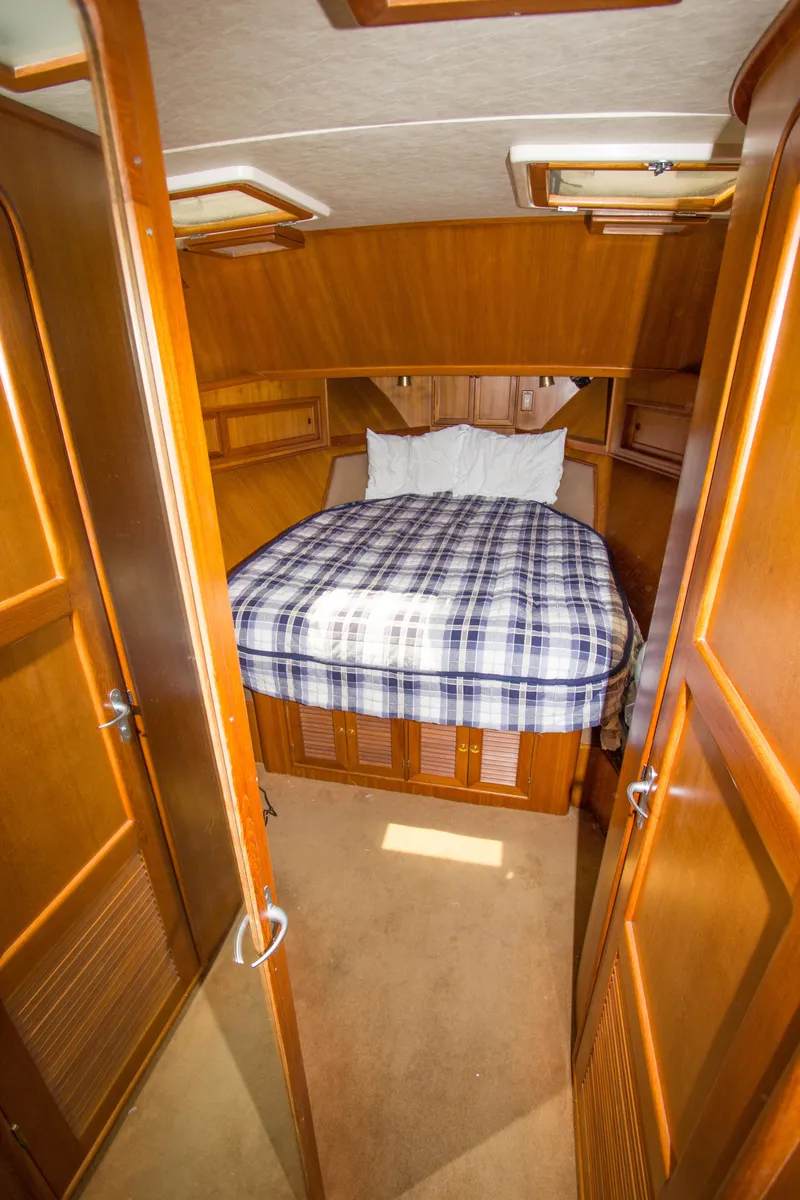 Slide: The Image of Cozy cabin interior of 1992 Offshore Yachts Sedan with plaid bedding and wooden finish. - 13