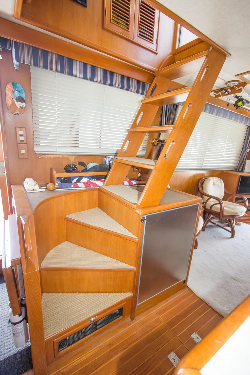 Slide: The Image of Interior of 1992 Offshore Yachts Sedan with wooden stairs and cozy seating area. - 19