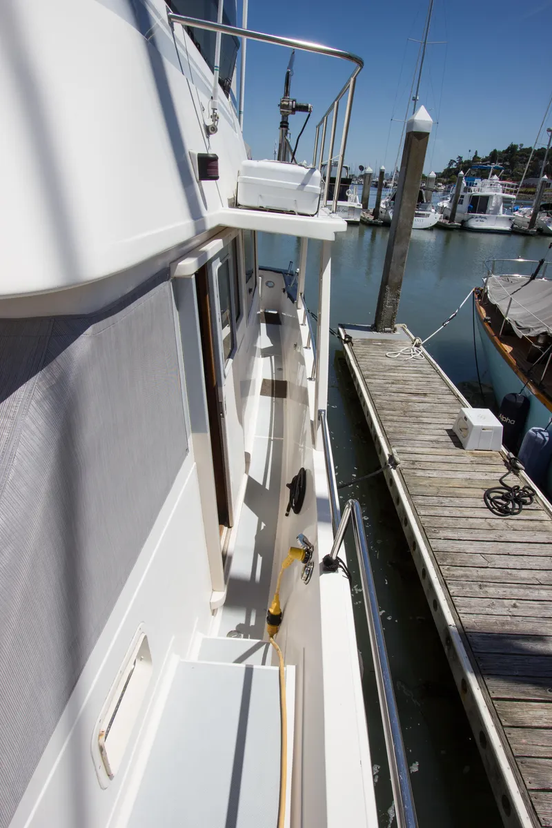 Slide: The Image of 1992 Offshore Yachts Sedan docked at marina, showcasing side deck and railing. - 28