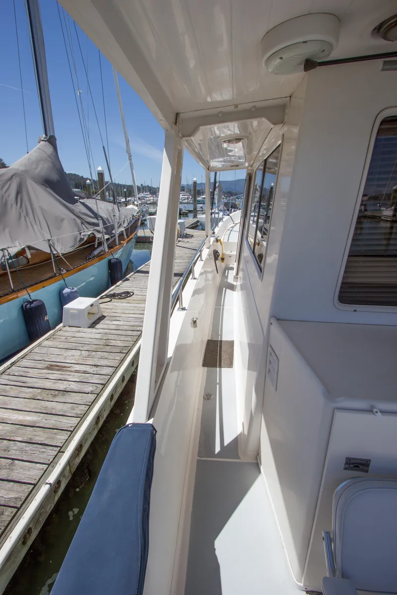 Slide: The Image of 1992 Offshore Yachts Sedan docked, showcasing sleek side deck and marina view. - 29