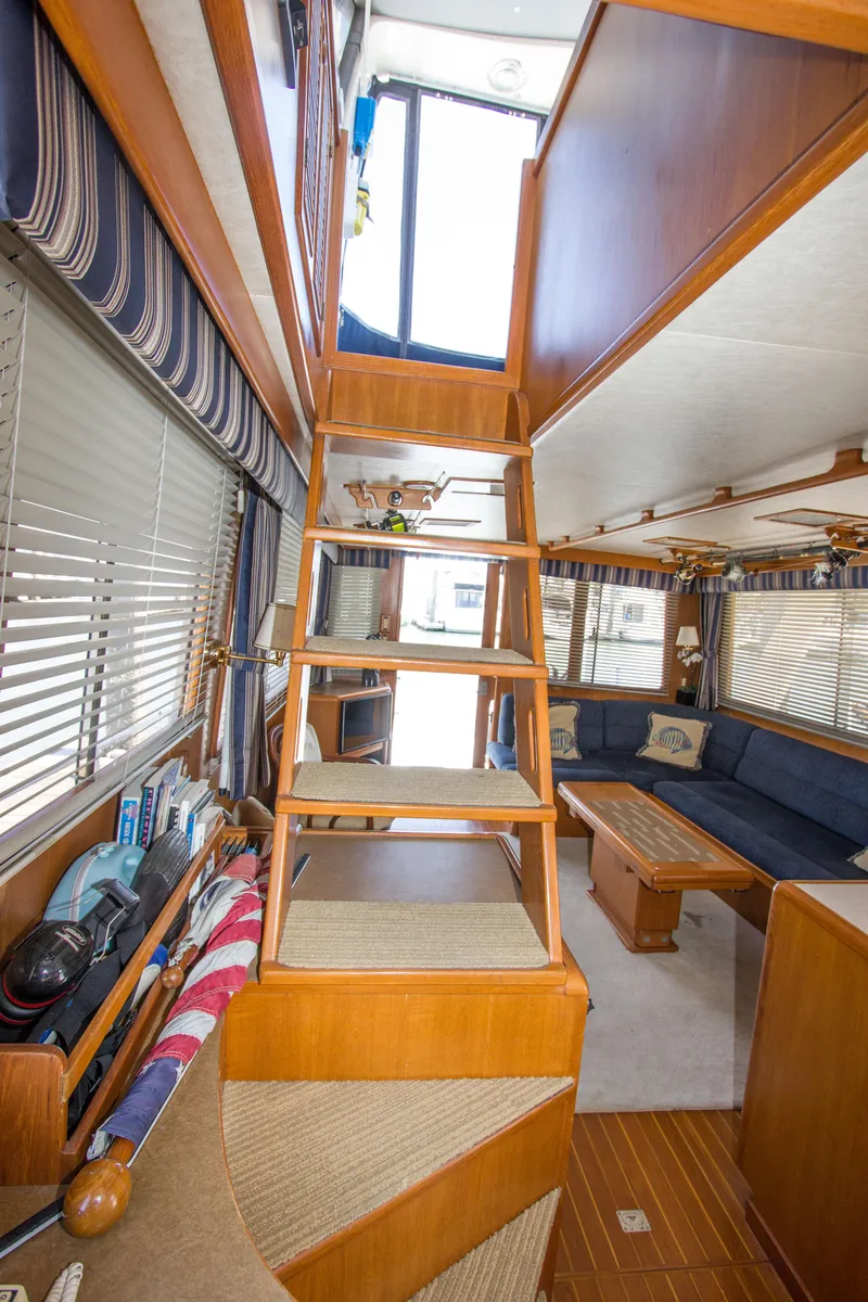 Slide: The Image of 1992 Offshore Yachts Sedan interior with wooden stairs and cozy seating area. - 4