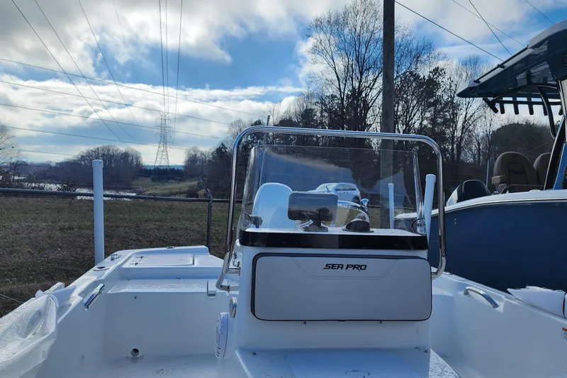Slide: The Image of 2025 Sea Pro 172 Bay boat with console, parked outdoors under cloudy sky. - 14