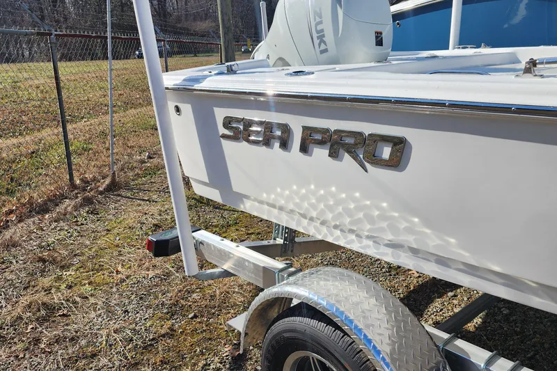 Slide: The Image of 2025 Sea Pro 172 Bay boat on trailer, featuring Suzuki engine, parked outdoors. - 9