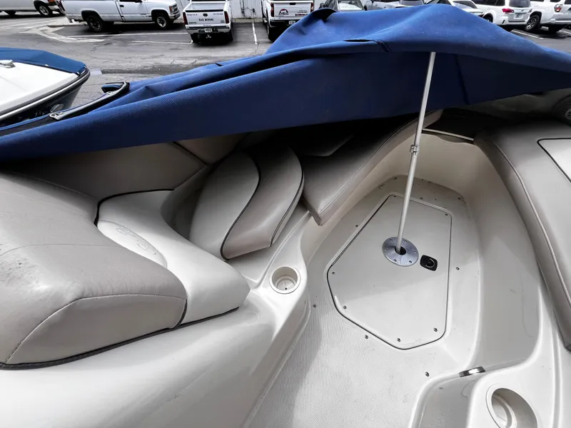 Slide: The Image of 2004 Sea Ray 240 Sundeck interior with blue cover and seating area. - 10