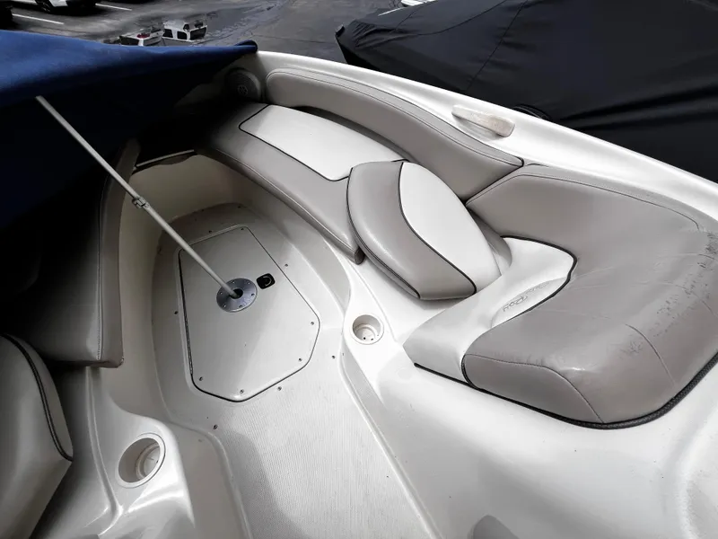 Slide: The Image of 2004 Sea Ray 240 Sundeck interior with beige seating and storage compartments. - 11