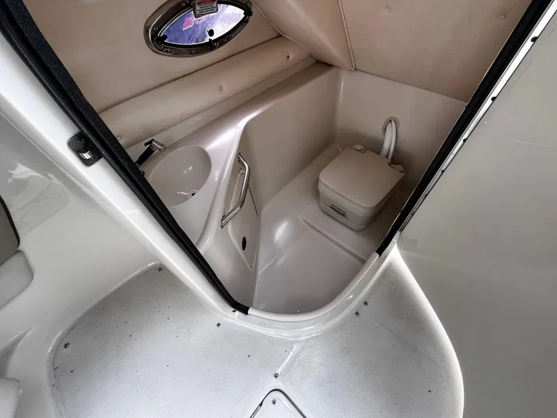 Slide: The Image of 2004 Sea Ray 240 Sundeck interior with compact marine toilet and sink. - 12