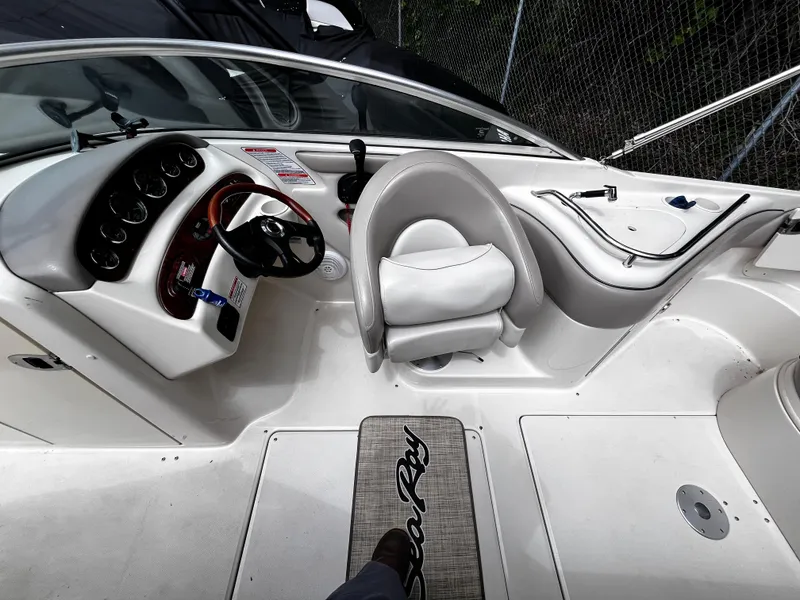 Slide: The Image of 2004 Sea Ray 240 Sundeck cockpit with steering wheel and seating area. - 15
