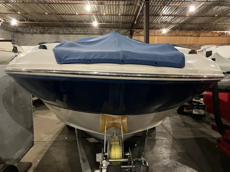 Slide: The Image of 2004 Sea Ray 240 Sundeck boat with blue cover in storage facility. - 3