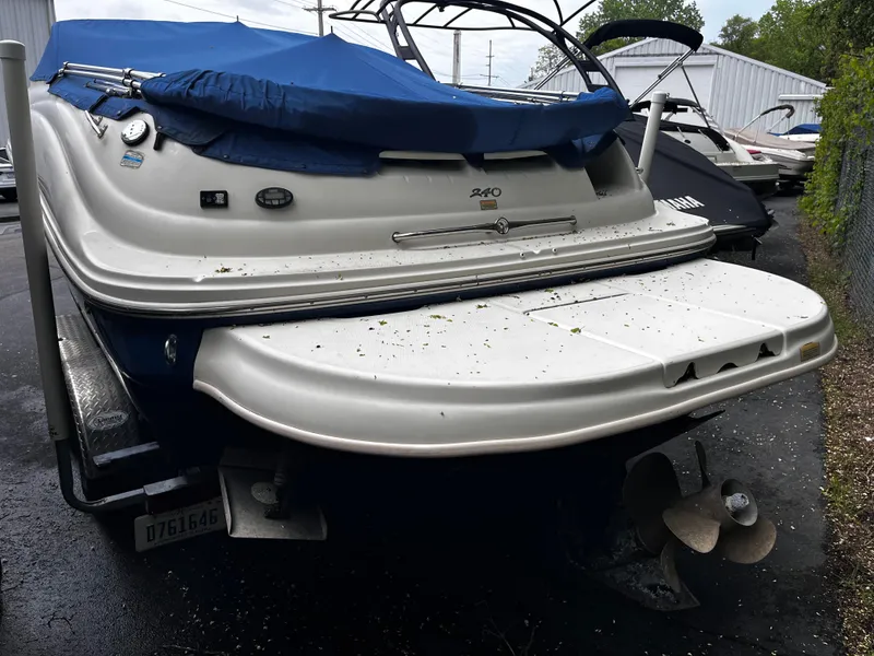 Slide: The Image of 2004 Sea Ray 240 Sundeck boat with blue cover, rear view, on a trailer. - 5
