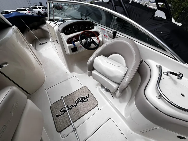 Slide: The Image of 2004 Sea Ray 240 Sundeck boat interior with steering wheel and seating area. - 8