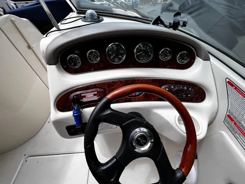 Slide: The Image of 2004 Sea Ray 240 Sundeck dashboard with gauges and steering wheel. - 9