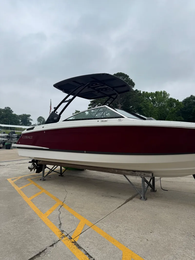 Slide: The Image of 2023 Cobalt R4 boat with maroon hull on a trailer, parked outdoors. - 3