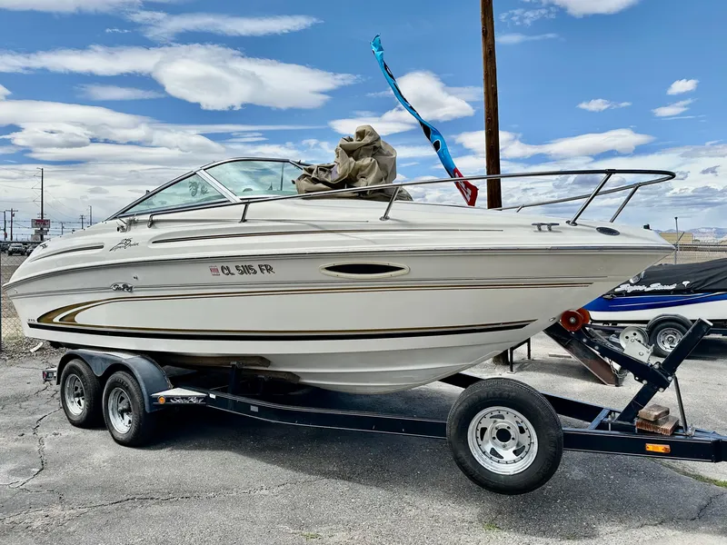 Slide: The Image of 2000 Sea Ray 215 Express Cruiser on trailer under cloudy sky. - 1