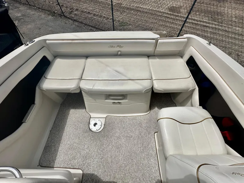 Slide: The Image of 2000 Sea Ray 215 Express Cruiser interior with white seating and carpeted floor. - 10