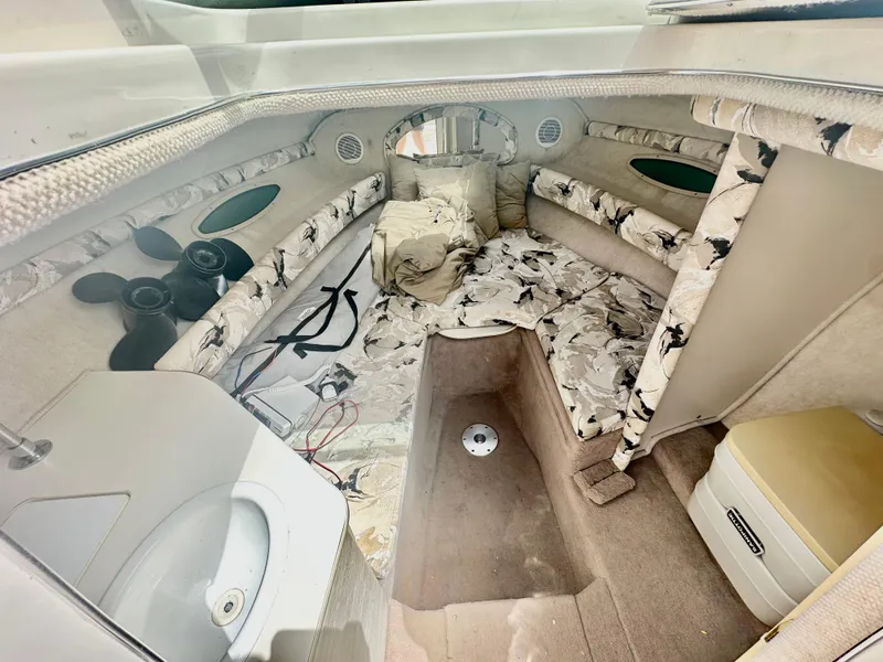 Slide: The Image of Interior of 2000 Sea Ray 215 Express Cruiser with patterned upholstery and compact amenities. - 11