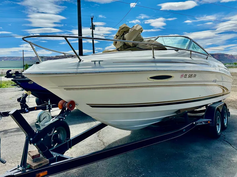 Slide: The Image of 2000 Sea Ray 215 Express Cruiser on trailer under a blue sky. - 6