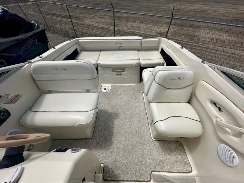 Slide: The Image of 2000 Sea Ray 215 Express Cruiser interior with beige seating and carpeted floor. - 9
