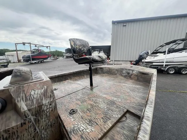 Slide: The Image of 2023 G3 17 CCJ boat with camouflage design, parked near a storage facility. - 6