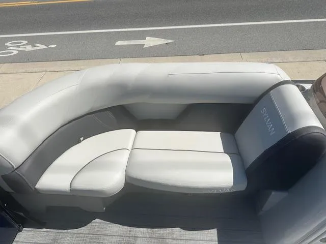 Slide: The Image of 2022 Sylvan Mirage X3 Tri Toon boat seating, featuring sleek white and gray upholstery. - 10