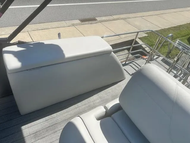 Slide: The Image of 2022 Sylvan Mirage X3 Tri Toon boat interior with white seating and railing. - 11
