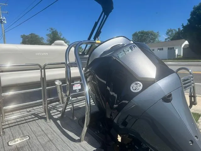 Slide: The Image of 2022 Sylvan Mirage X3 Tri Toon boat with powerful outboard motor, docked on a sunny day. - 15