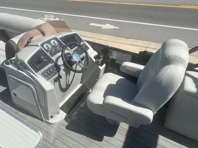 Slide: The Image of 2022 Sylvan Mirage X3 Tri Toon boat cockpit with steering wheel and captain's chair. - 3