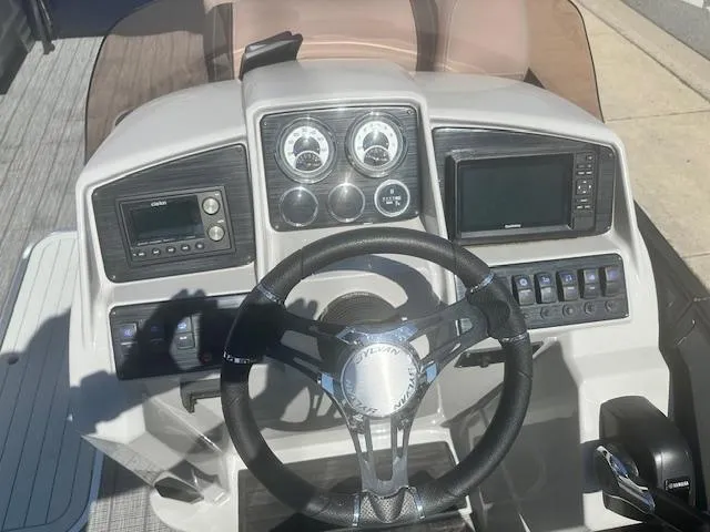 Slide: The Image of 2022 Sylvan Mirage X3 Tri Toon dashboard with steering wheel and control panel. - 4