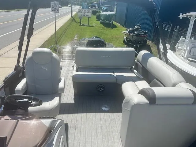 Slide: The Image of 2022 Sylvan Mirage X3 Tri Toon boat interior with plush seating and steering console. - 7