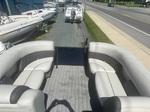 Slide: The Image of 2022 Sylvan Mirage X3 Tri Toon boat with spacious seating, parked near a road. - 8