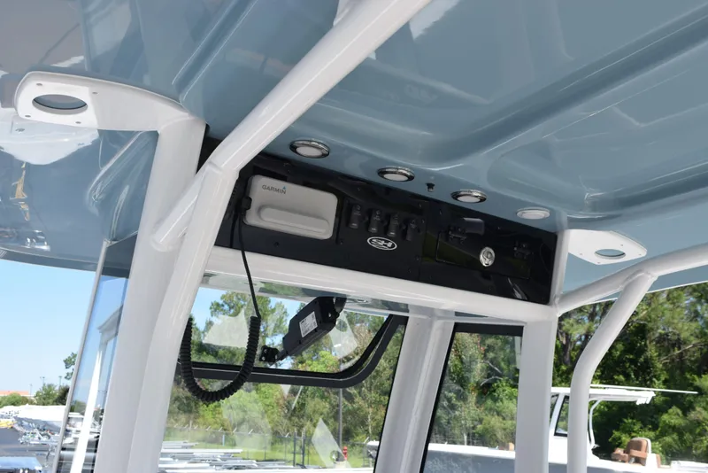 Slide: The Image of 2025 Sea Hunt Ultra 245 SE boat console with electronic controls and overhead storage. - 10