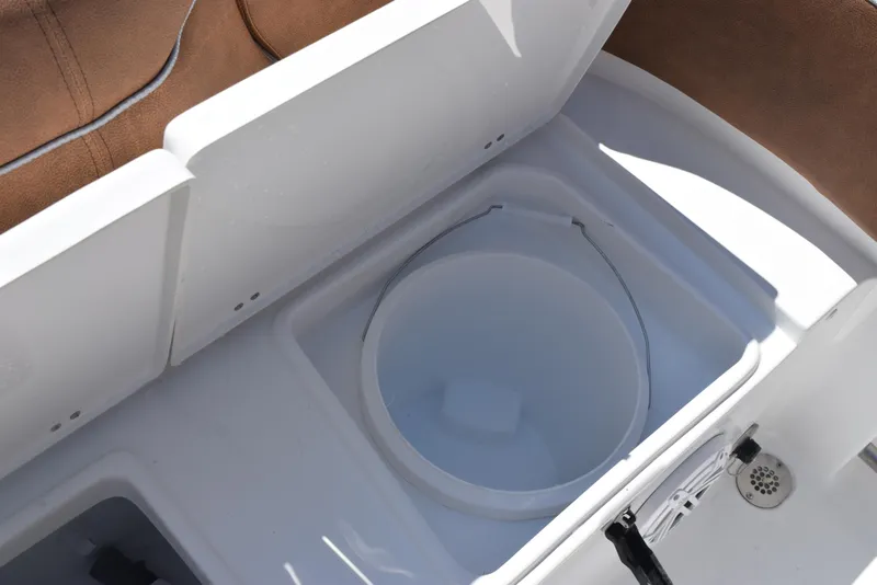Slide: The Image of Livewell compartment on 2025 Sea Hunt Ultra 245 SE boat, featuring white interior and brown seating. - 23