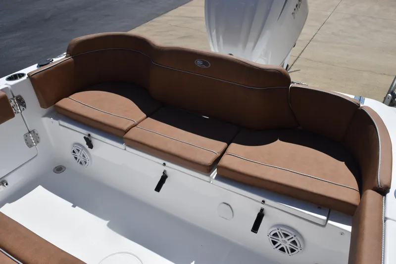 Slide: The Image of 2025 Sea Hunt Ultra 245 SE boat with brown cushioned seating and white deck. - 8