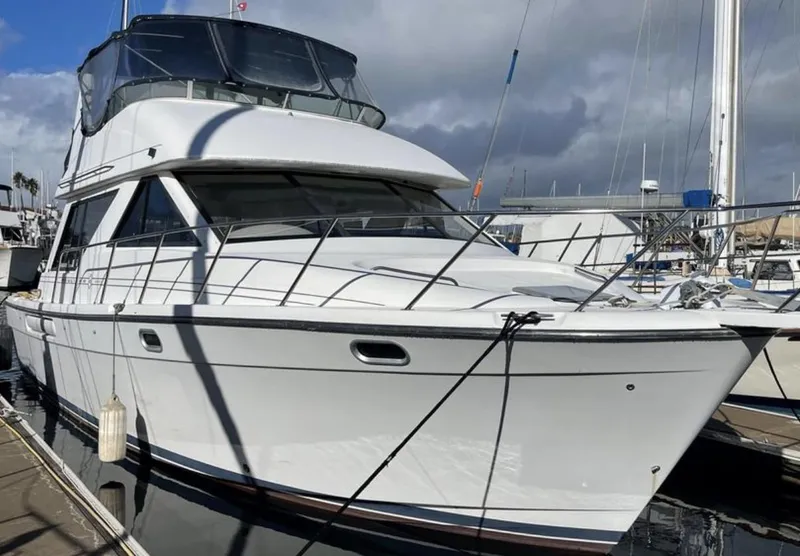 The Image of 2000 Bayliner 3988 yacht docked at marina under cloudy sky. - 1