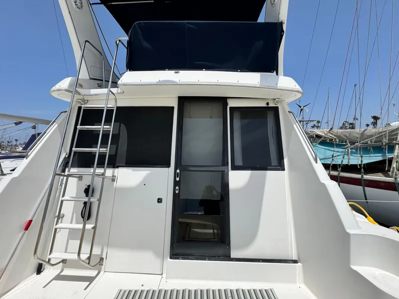 Slide: The Image of Bayliner 3988 yacht, 2000 model, rear view with ladder and door, docked at marina. - 19